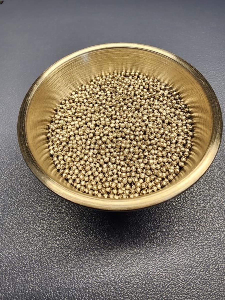 Stainless steel shot in a brass dish — the fill used in freestyle footbags