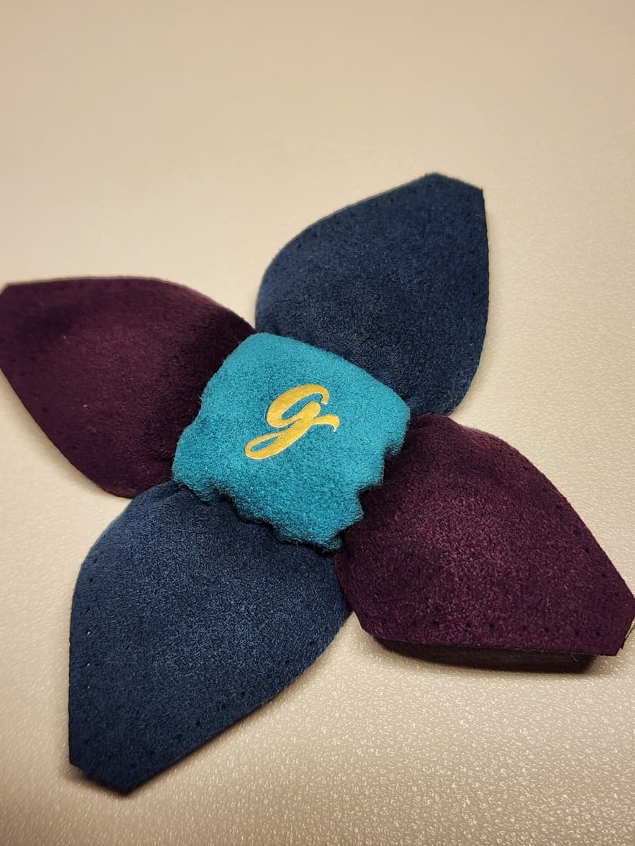 A 14-panel footbag with the first panel stitched in, surrounding panels still loose and their stitch holes visible